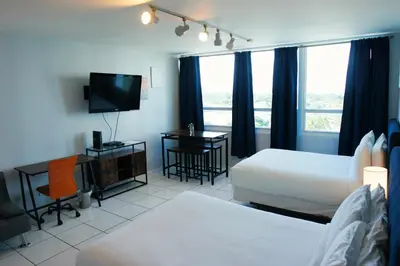 a hotel room with two beds and a flat screen tv at Castle 705 in Miami Beach
