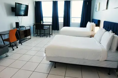 a hotel room with two beds and a television at Castle 705 in Miami Beach