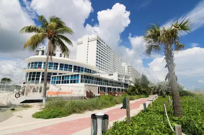 a large building with palm trees in front of it at Castle 705 in Miami Beach