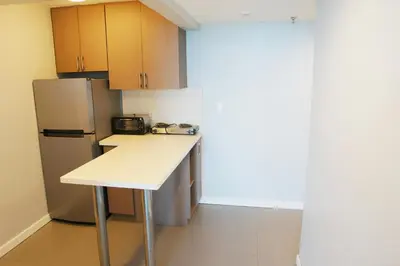 a kitchen with a white counter and a refrigerator at Castle 835 Oceanview studio on beach with pool, gym, bars, and FREE Parking in Miami Beach