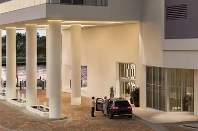 two people standing next to a car in a building at Luxury Condo with Jacuzzi and Amenities in Hollywood