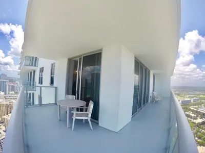 a balcony with a table and chairs on a building at Luxury Condo with Jacuzzi and Amenities in Hollywood