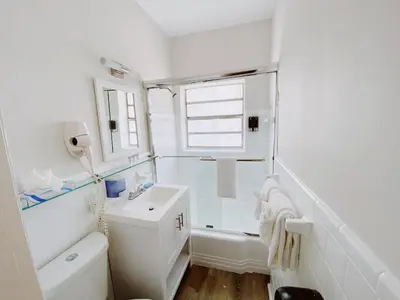 a white bathroom with a sink and a tub at Miami International by Lowkl in Miami Beach