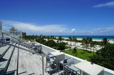 a balcony with tables and chairs and the beach at Deluxe apartments at the Congress in Miami Beach