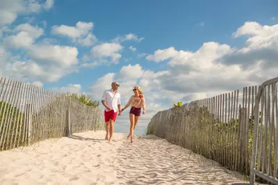 a man and a woman walking on the beach at The Samantha by Lowkl in Miami Beach