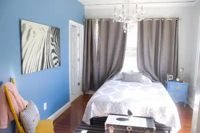 a bedroom with a bed and a blue wall at Private Suite Mins from MIA Free Parking in Miami