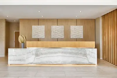 a lobby with a large marble reception desk at AC Hotel by Marriott Fort Lauderdale Beach in Fort Lauderdale