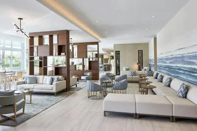 a living room with couches and chairs and the ocean at AC Hotel by Marriott Fort Lauderdale Beach in Fort Lauderdale