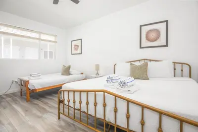 a bedroom with two beds and a table at Boutique Apartments Flamingo in Miami Beach