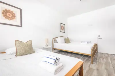 two beds in a room with white walls at Boutique Apartments Flamingo in Miami Beach