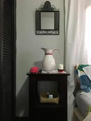 a vase on a table in a bedroom with a mirror at The Jewel of Little Havana in Miami