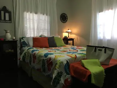 a bedroom with a bed with a colorful comforter at The Jewel of Little Havana in Miami