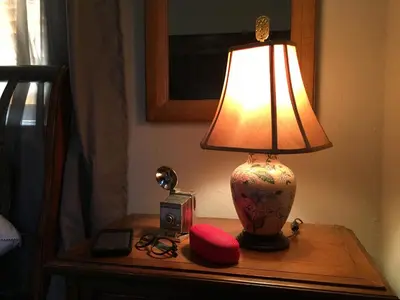 a lamp on a table with a alarm clock and a clock at Private room in the Heart of Little Havana in Miami