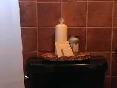 a candle and a basket on top of a toilet at Private room in the Heart of Little Havana in Miami