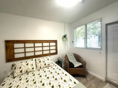 a bedroom with a bed and a chair and a window at Studio close to Everything in Miami