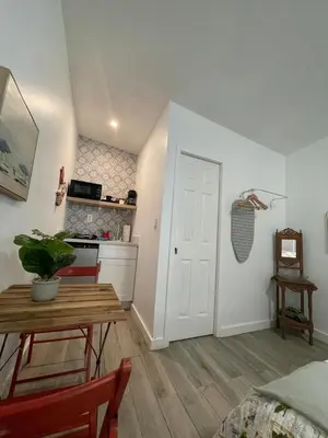 a living room with a table and a kitchen at Studio close to Everything in Miami