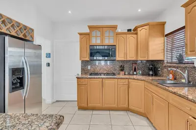 a kitchen with wooden cabinets and a stainless steel refrigerator at Private room in Little Havana in Miami
