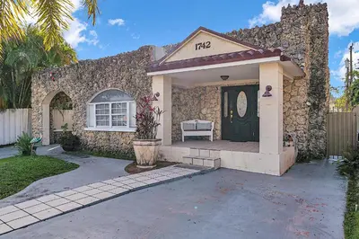 a stone house with a black door and a porch at Private Studio in Little Havana in Miami