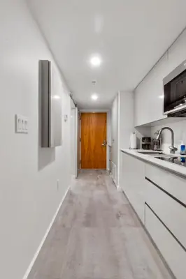 a kitchen with white counters and a wooden door at Elite Brickell Studio on the Bay in Miami