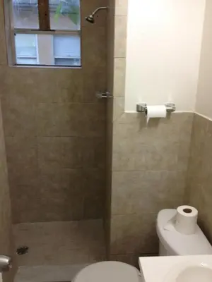 a bathroom with a shower with a toilet and a window at 1 Bedroom Apt near Coconut Grove in Miami