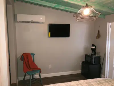 a bedroom with a bed and a chair and a tv on the wall at Independent Studio in Little Havana in Miami