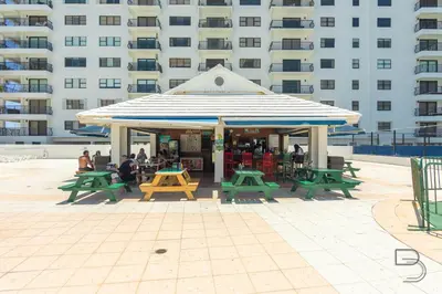 a gazebo with green picnic tables and a building at Girasole Suites in Miami Beach