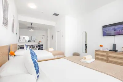 a bedroom with two beds and a flat screen tv at Girasole Suites in Miami Beach