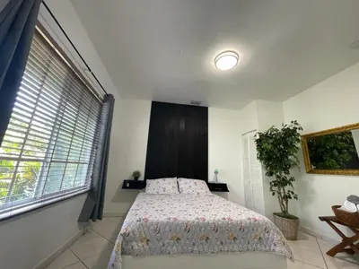 a bedroom with a bed and a large window at Private Suite next to Calle Ocho in Miami