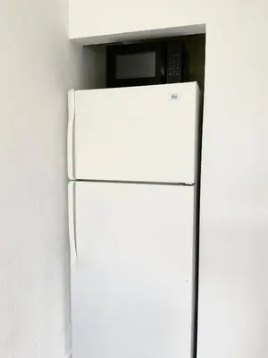 a white refrigerator with a microwave on top of it at Adorable private apartments in the Heart of Miami! in Miami