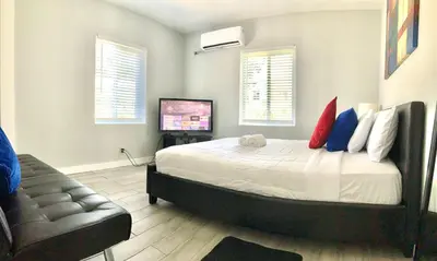 a bedroom with a bed and a couch and a television at Adorable private apartments in the Heart of Miami! in Miami