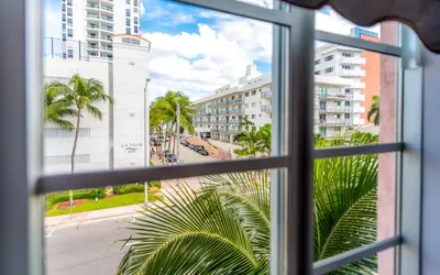 a window with a view of a street and buildings at Secret Garden Miami Beach in Miami Beach