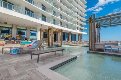 a pool at a hotel with chairs and a building at Ocean view 1 bed- Steps from the beach! in Hallandale Beach