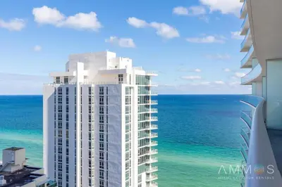 a view of a tall white building next to the ocean at Ocean view 1 bed- Steps from the beach! in Hallandale Beach