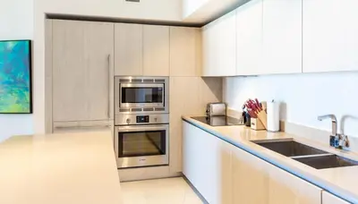 a kitchen with stainless steel appliances and white cabinets at Ocean view 1 bed- Steps from the beach! in Hallandale Beach