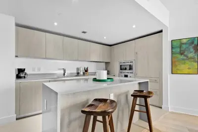 a kitchen with a counter and two bar stools at Ocean view 1 bed- Steps from the beach! in Hallandale Beach