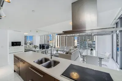 a kitchen with a sink and a living room at Icon Brickell Miami in Miami