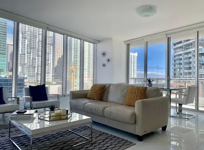 a living room with a couch and large windows at Icon Brickell Miami in Miami
