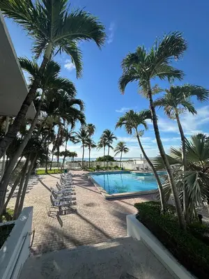 a resort with a pool and palm trees and chairs at Casablanca on the beach in Miami Beach