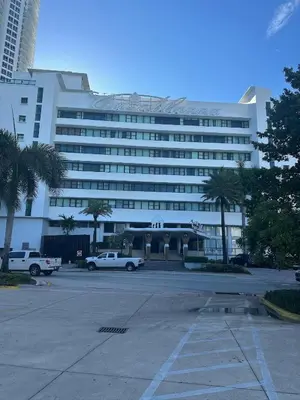 a large white building with cars parked in a parking lot at Casablanca on the beach in Miami Beach