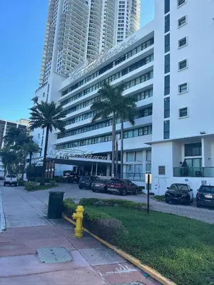 a yellow fire hydrant in front of a large building at Casablanca on the beach in Miami Beach