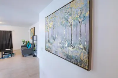 a large painting of trees on a wall in a living room at Spacious entire Apartment with Free Parking in Hollywood