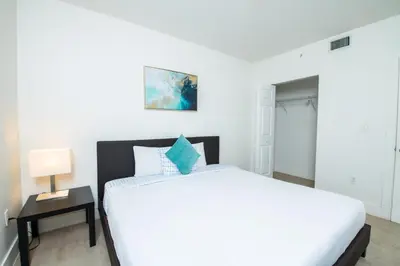 a bedroom with a large white bed and a table at Spacious entire Apartment with Free Parking in Hollywood