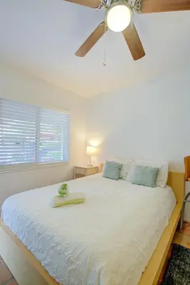 a bedroom with a white bed with a ceiling fan at Efficiency 2 on water Las Olas, beach and free kayaks in Fort Lauderdale