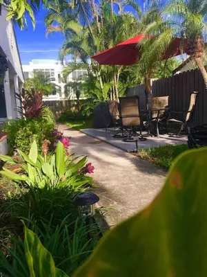 a patio with chairs and a red umbrella at Efficiency 2 on water Las Olas, beach and free kayaks in Fort Lauderdale