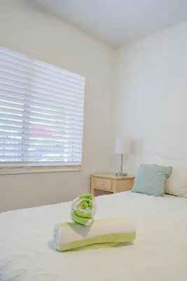 a white bed with a towel on it with a window at Efficiency 2 on water Las Olas, beach and free kayaks in Fort Lauderdale