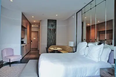 a bedroom with a large white bed and a table at Aluna Lux Suites at SLS Lux Brickell Building in Miami