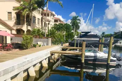 a boat docked at a dock next to a house at 1BR C direct on the water shared deck Free kayaks in Fort Lauderdale