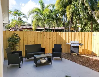 a patio with chairs and a table and a fence at Stylish & Newly-Renovated Suites near Las Olas in Fort Lauderdale