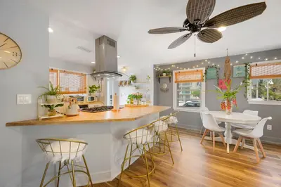 a kitchen with a table and chairs and a clock at Little “house” right on the beach in Hollywood