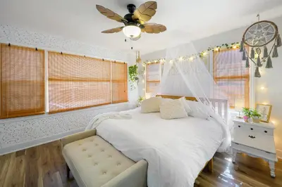 a bedroom with a white bed and a ceiling fan at Little “house” right on the beach in Hollywood